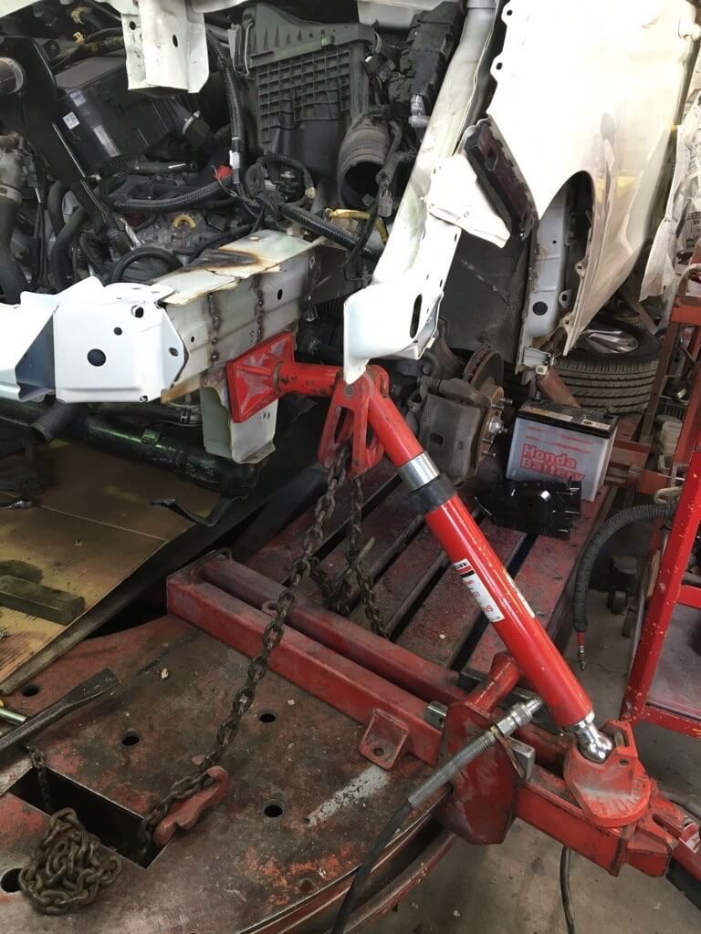 油圧式フレーム修正機を使っている様子